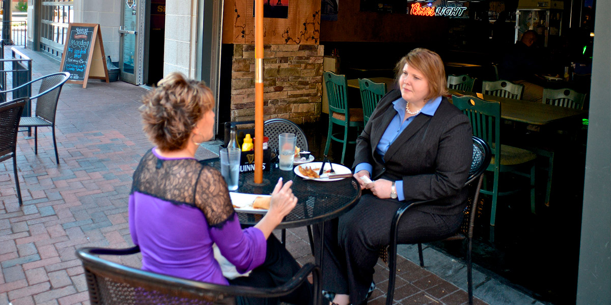 An image of two women dining on the Barley House brick patio in downtown Akron.