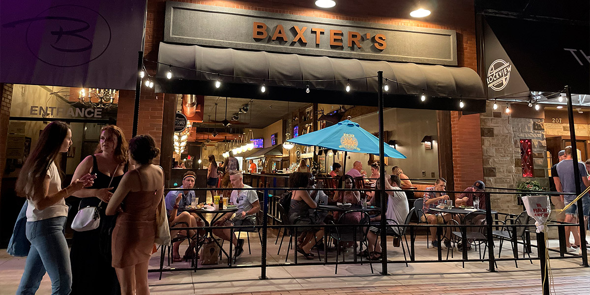 An image of people drinking on the Baxter's Bar outdoor patio in downtown Akron at night.