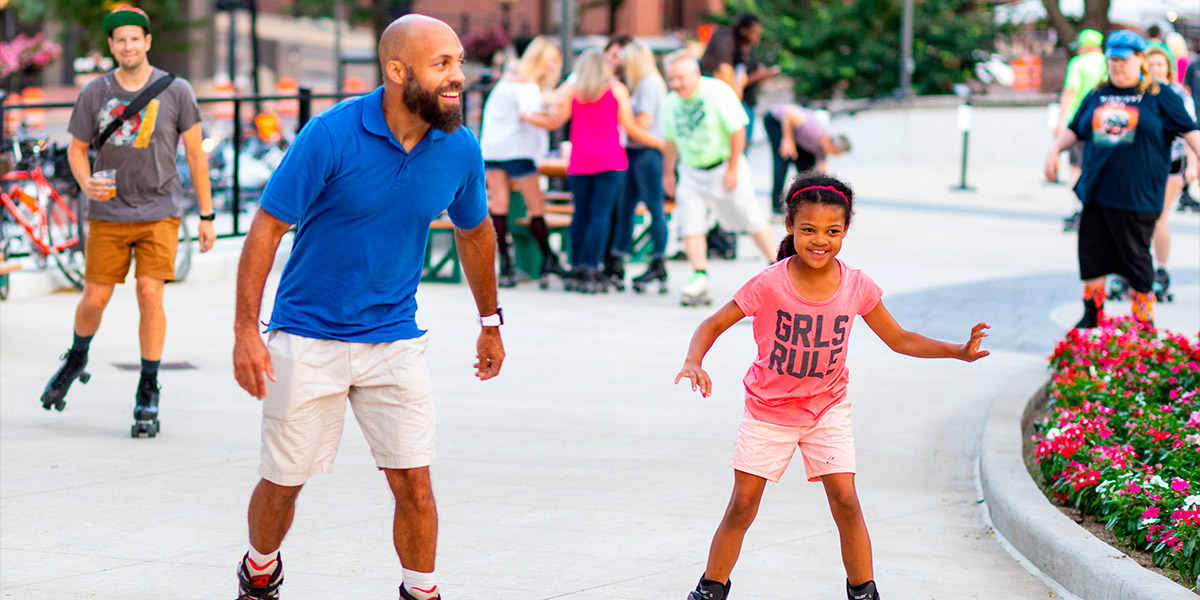 An image of a father and daughter roller blading at Cascade Plaza in downtown Akron.